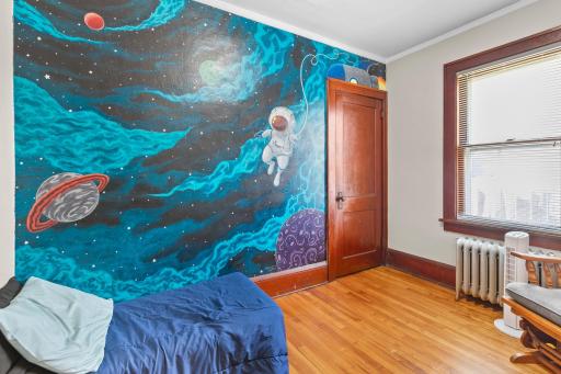 Bedroom #2. This wall mural is great for a kids room. Hardwood floors and original trim and doors.