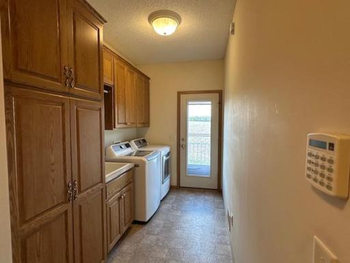 Laundry with sink and more cabinetry to grilling deck and the northern field