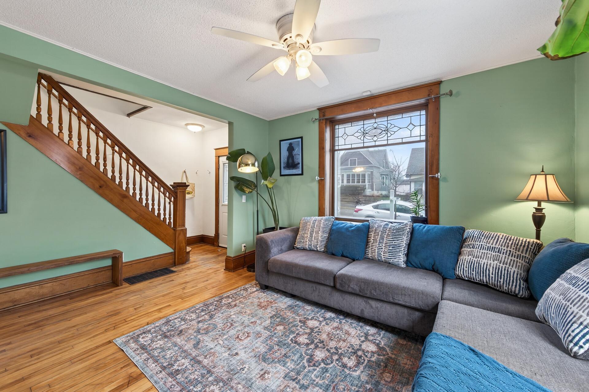 Beautiful original woodwork, hardwood floors, and a stained glass window overlooking the living space.