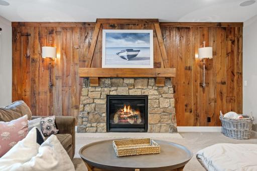 Stylish lower-level wood accent wall and gas fireplace.