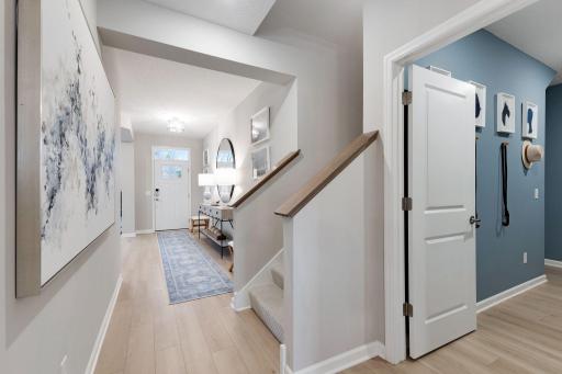 Front entry area, steps to upper level loft, and door to laundry/mudroom area off the garage