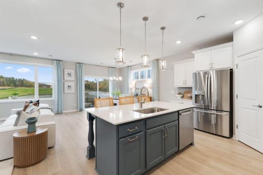 Open concept kitchen, dining, and family room give the home a light and airy feeling. Photo of model home, colors and finishes may vary.