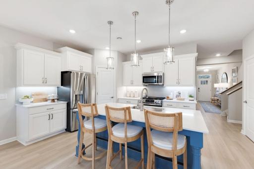 The heart of the home! Kitchen is spacious and features a center island perfect for everyday dining and prepping food. Photo of model home, colors and finishes may vary.