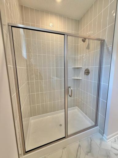 Actual home, with tiled shower and upgraded glass pivot door.