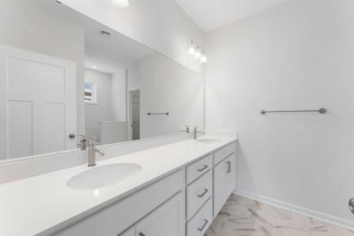 The primary bath is generously sized with dual sinks and tons of cabinet space!