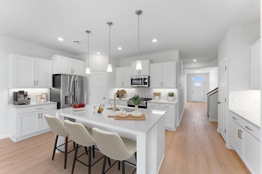 The heart of the home! Kitchen is spacious and features a center island perfect for everyday dining and prepping food. Photo is virtually staged.