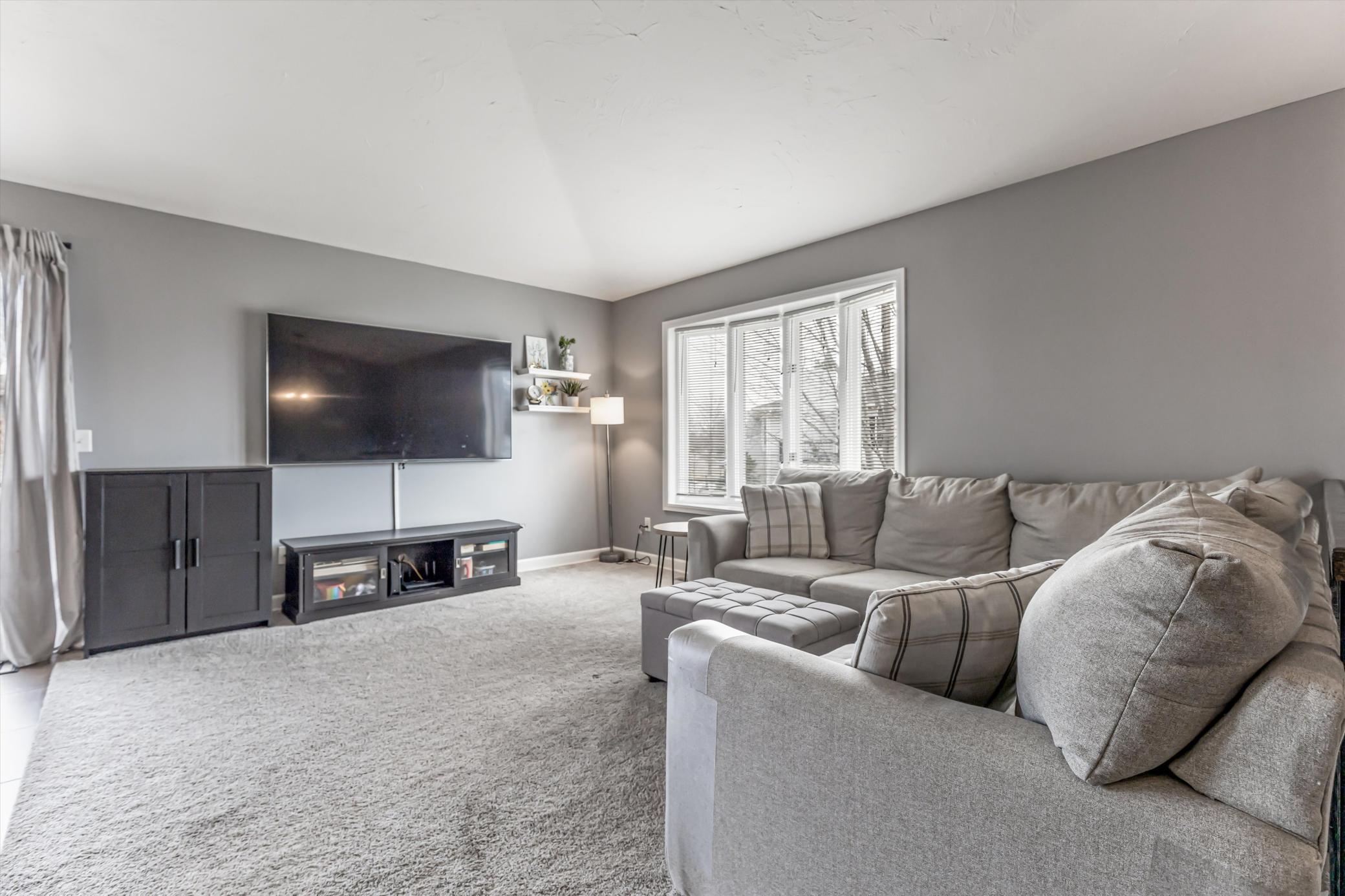 Spacious living room filled with natural light, ideal for relaxing or entertaining.