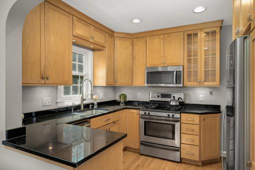 The kitchen boasts thoughtful, custom cabinetry, quartz countertops & stainless appliances.