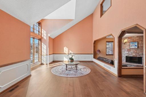 âBright and open living space featuring soaring vaulted ceilings, warm natural light, and a spacious layout with elegant wood flooring and architectural details.â