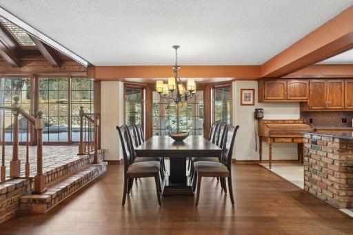 âBright dining area with large windows and warm wood floors, offering easy flow from the four-season porch to the kitchen, and direct access to the octagonal screened porch for effortless indoor-outdoor dining.â