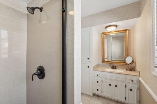 âPrimary bathroom includes a second vanity with ample storage and an updated walk-in shower, offering a bright and functional layout with neutral finishes.â