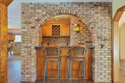 âCharming brick bar with a classic arched opening, wood cabinetry, wine storage, and counter seatingâperfectly positioned for entertaining with warm, old-world character and craftsmanship.â
