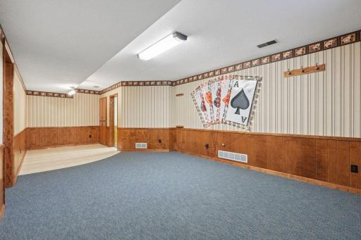 âLower-level rec room with wood wainscoting, patterned wall detail, and a large open layout with space for games, media, or hobbiesâideal for flexible everyday use.â