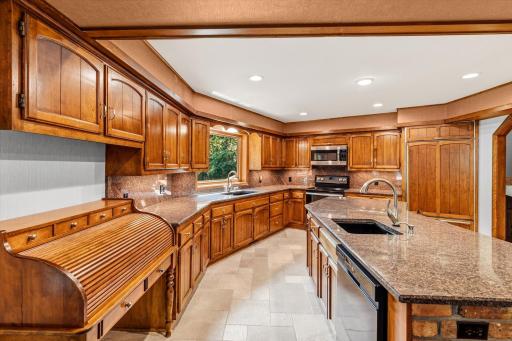 Kithen has 2 sinks, one overlooking private backyard, and a rolltop desk adds to both function and interest.