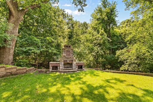 Beautiful masonary fireplace in the expansive wooded and private backyard.
