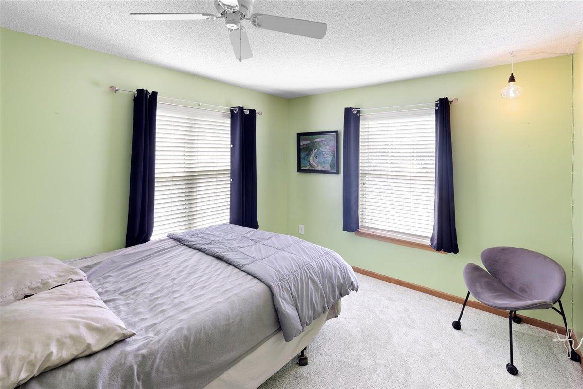 Bright secondary bedroom with large windows, also has a large walk-in closet for ample storage.