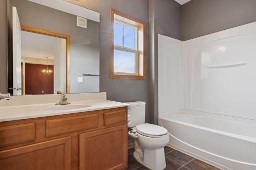 Full bathroom with large vanity, ample cabinet storage, and tub and shower combination.