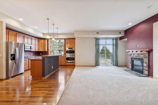 Open-concept layout showcasing the kitchen, dining, and living areas with hardwood floors, center island, and seamless flow throughout.