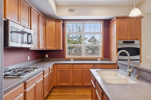 Bright and functional kitchen design with large windows offering great views and generous counter space for everyday living and entertaining.