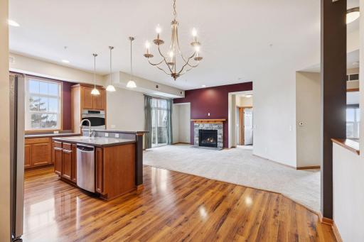 Open-concept layout showcasing the kitchen, dining, and living areas with hardwood floors, center island, and seamless flow throughout.