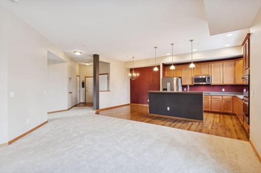 Spacious open-concept living area featuring plush carpeting, seamless flow into the kitchen and dining space, and plenty of room for comfortable everyday living.