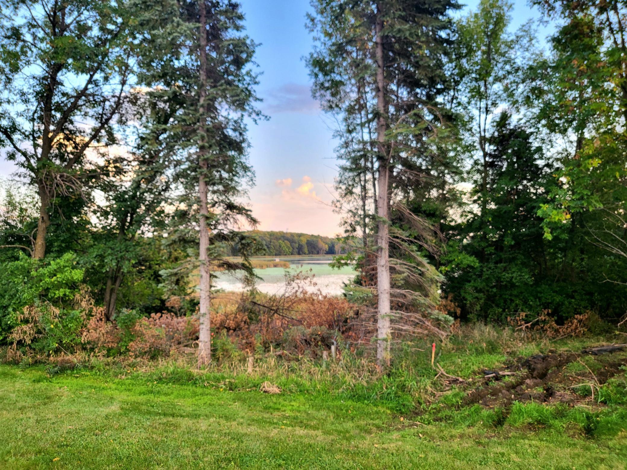 View to the lake with a garage location to the left, front entrance straight ahead with the home extending to the right..jpg