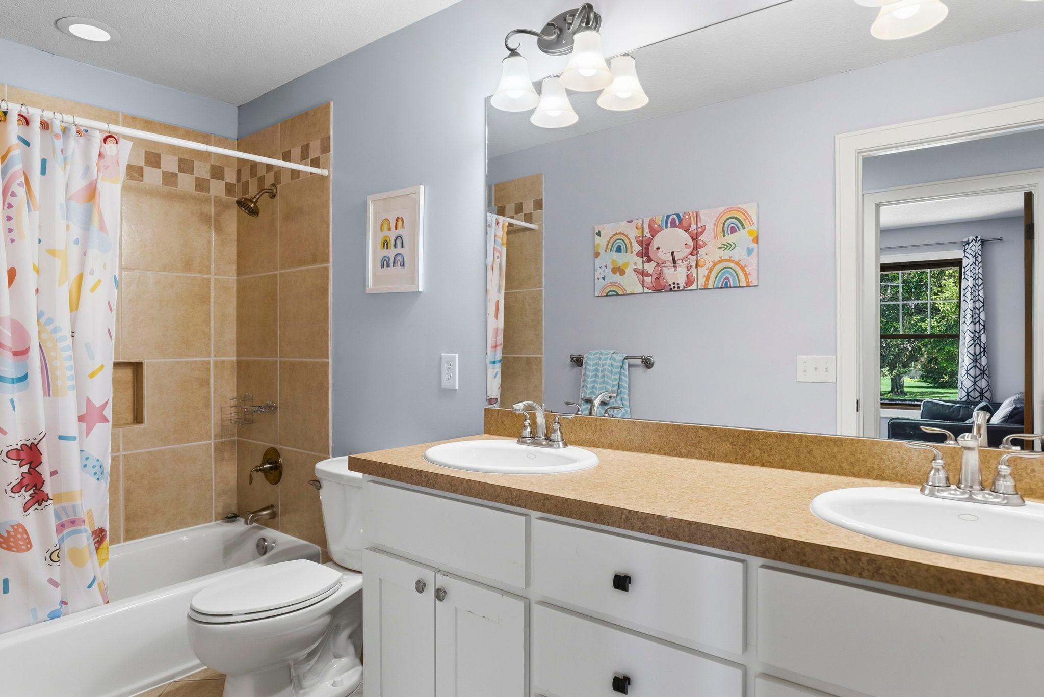 Full bath on the main level with dual sinks.