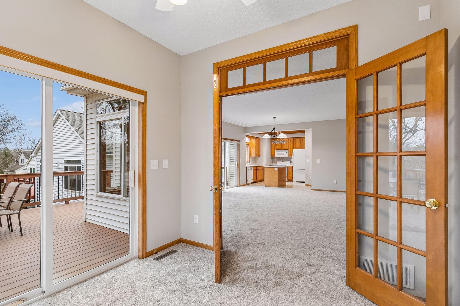The sunroom walks out to the composite deck with stairs. Transom windows above the french doors bring in living room light even when this room is closed off. Great space