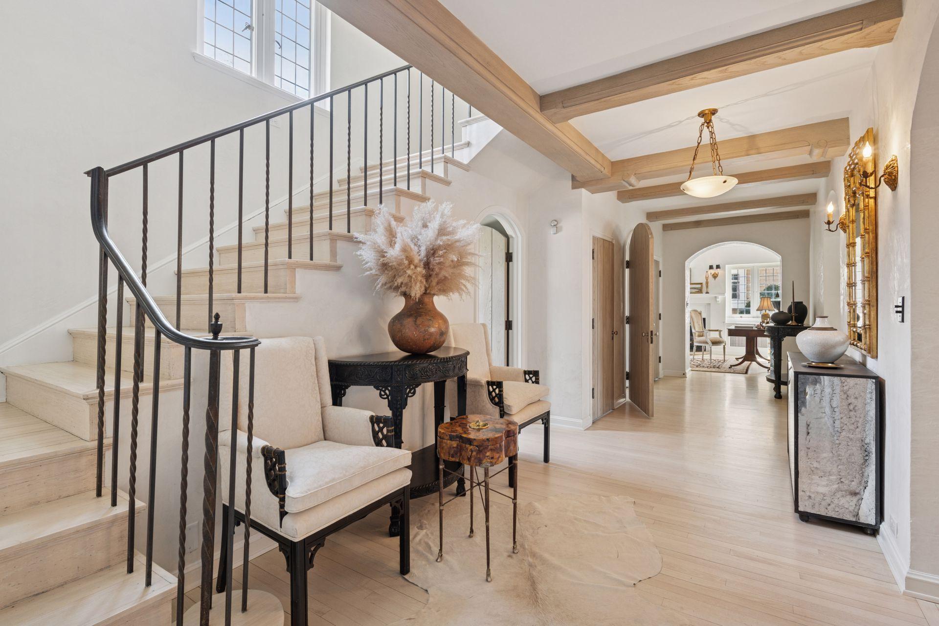 Gracious formal entrance hall with two walk-in coat closets, original beamed ceilings, and wide arched doorways to a main level office, the living room, and dining room. Hardwood floors throughout the main and upper levels.