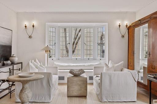 An additional living room seating area features a bay window with a built-in window seat.