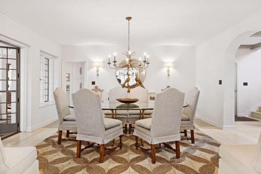 Spacious formal dining room with two wide arched doorways, kitchen access, and divided light French doors leading to the family room.