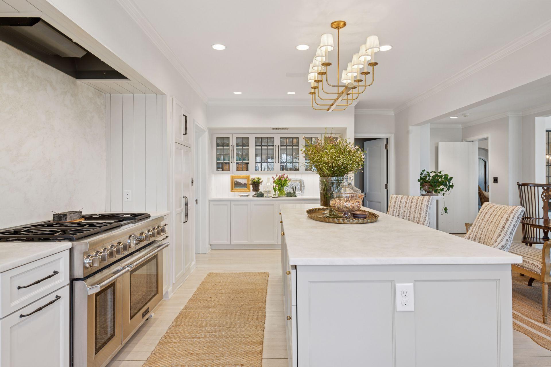 A chef's delight with a six burner range and double oven, concealed exhaust hood, and warming drawer. Abundant counter space and spacious center island with seating.