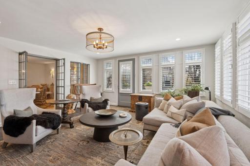 The main level family room is spacious and filled with natural light. Wide doorways connect to the kitchen. French doors lead to the dining room. An exterior door leads to the patio.