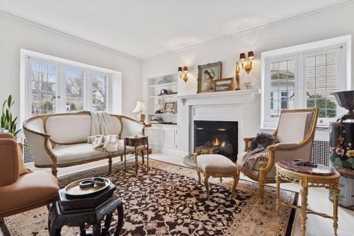 Cozy main level den/office with east and south facing windows along with a gas log set fireplace and built-in library shelving with lower cabinets.