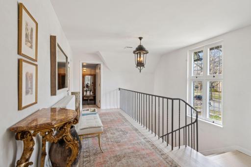 An elegant primary staircase leads to five upper level bedrooms and four bathrooms. Gorgeous divided light windows provide beautiful natural light from the east.