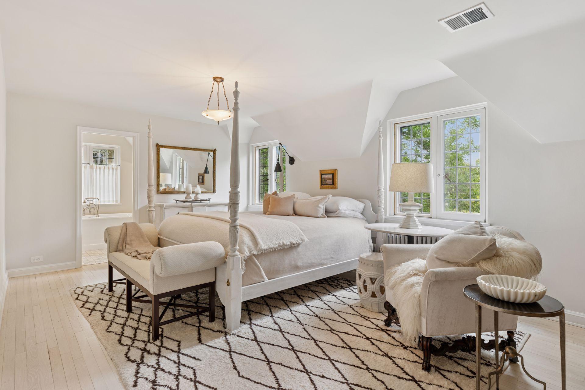 A serene primary bedroom features hardwood floors, two walk-in closets, and a recently renovated primary bath. West and south facing windows provide abundant light and sunset views. Seasonal lake views.