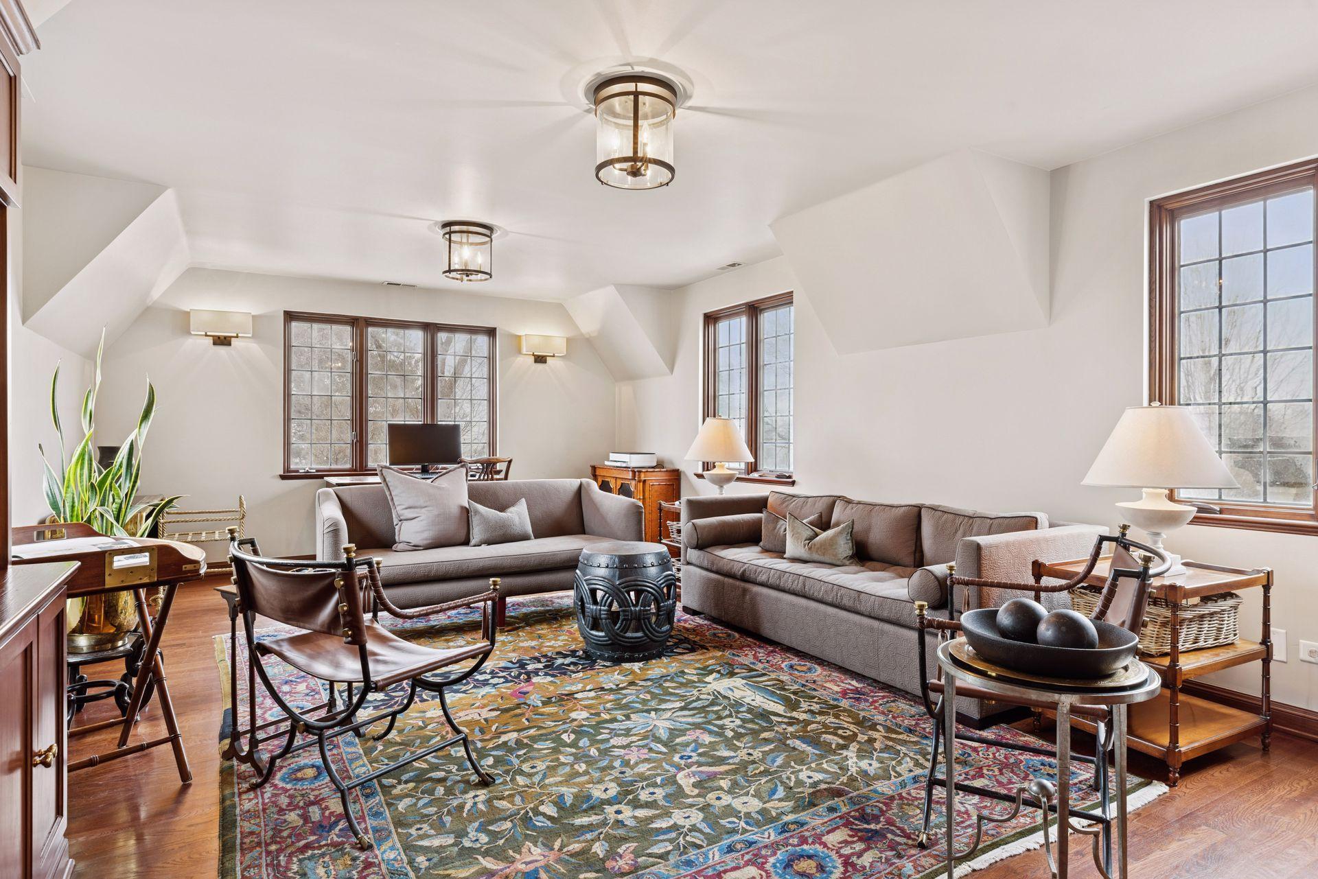 The spacious 5th bedroom is currently used as an office and upper level den. Three walls of windows provide wonderful natural light, sunset views, and seasonal lake views.