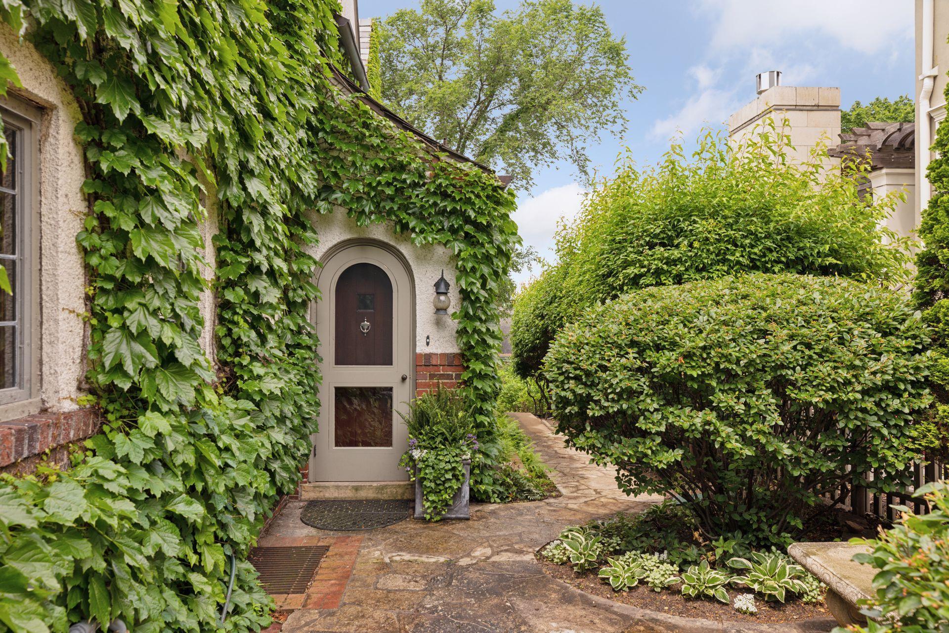 A charming side entrance with an additional side patio and stone pathway leading to the garden shed. A gate leads to the front driveway.