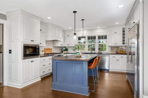 This kitchen features honed, leathered granite countertops, marble backsplash and commercial-grade appliances. The kitchen looks out over the front of the property and the wall of arborvitae adds privacy to the front yard.