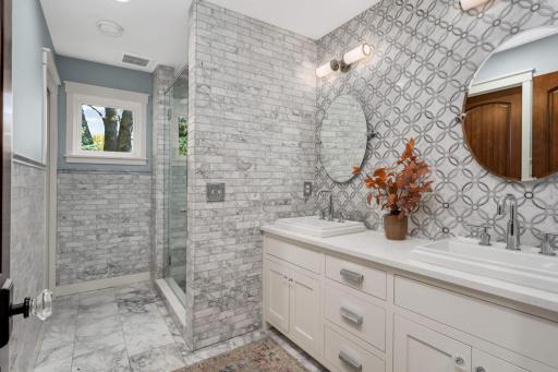 The primary bathroom features luxe marble tile, heated floors, a luxury walk-in shower with a bench, a private water closet and a walk-in closet with organizers.