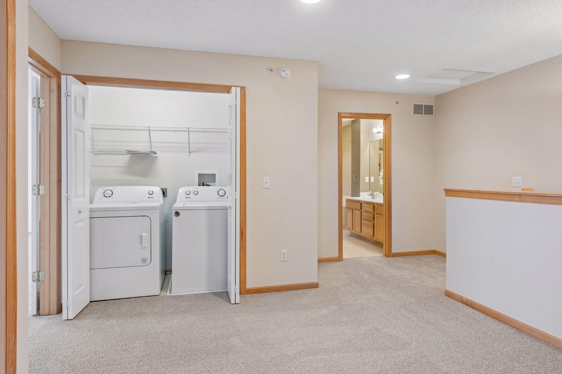 The laundry is located just outside the bedroom areas in the loft.