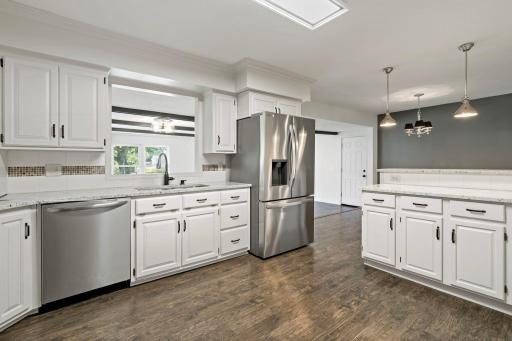 The kitchen features an open layout to the informal dining area and living rooms on the main level.