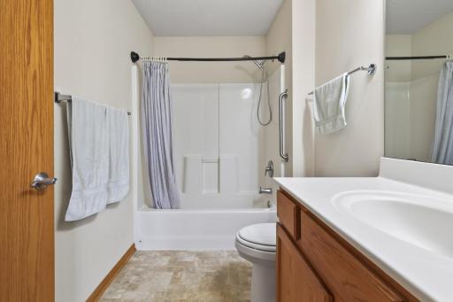 The en-suite bathroom features a convenient shower/tub combo and neutral tone flooring and paint.