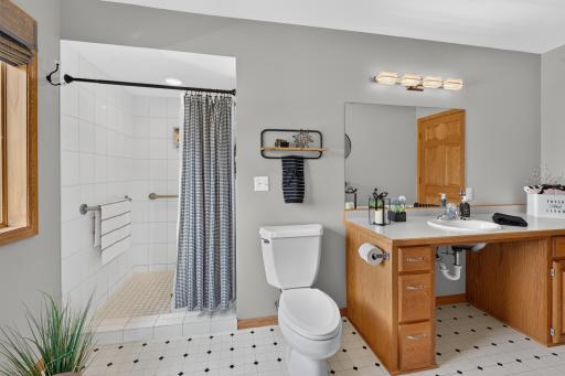 Main floor 3/4 bathroom offers handicap features with grab bars and roll under sink.