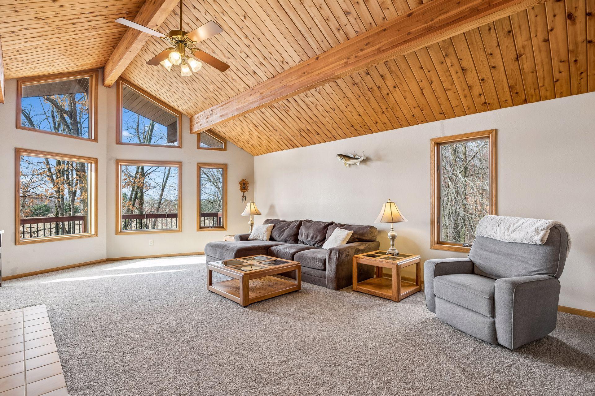 Stunning living room with cedar vaulted ceilings and dramatic stacked windows.
