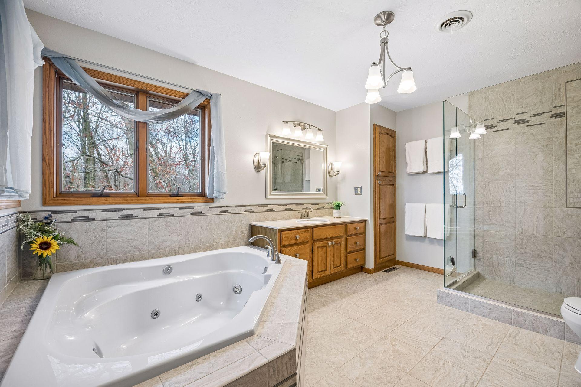 Spacious bathroom with soaking tub and glass shower.