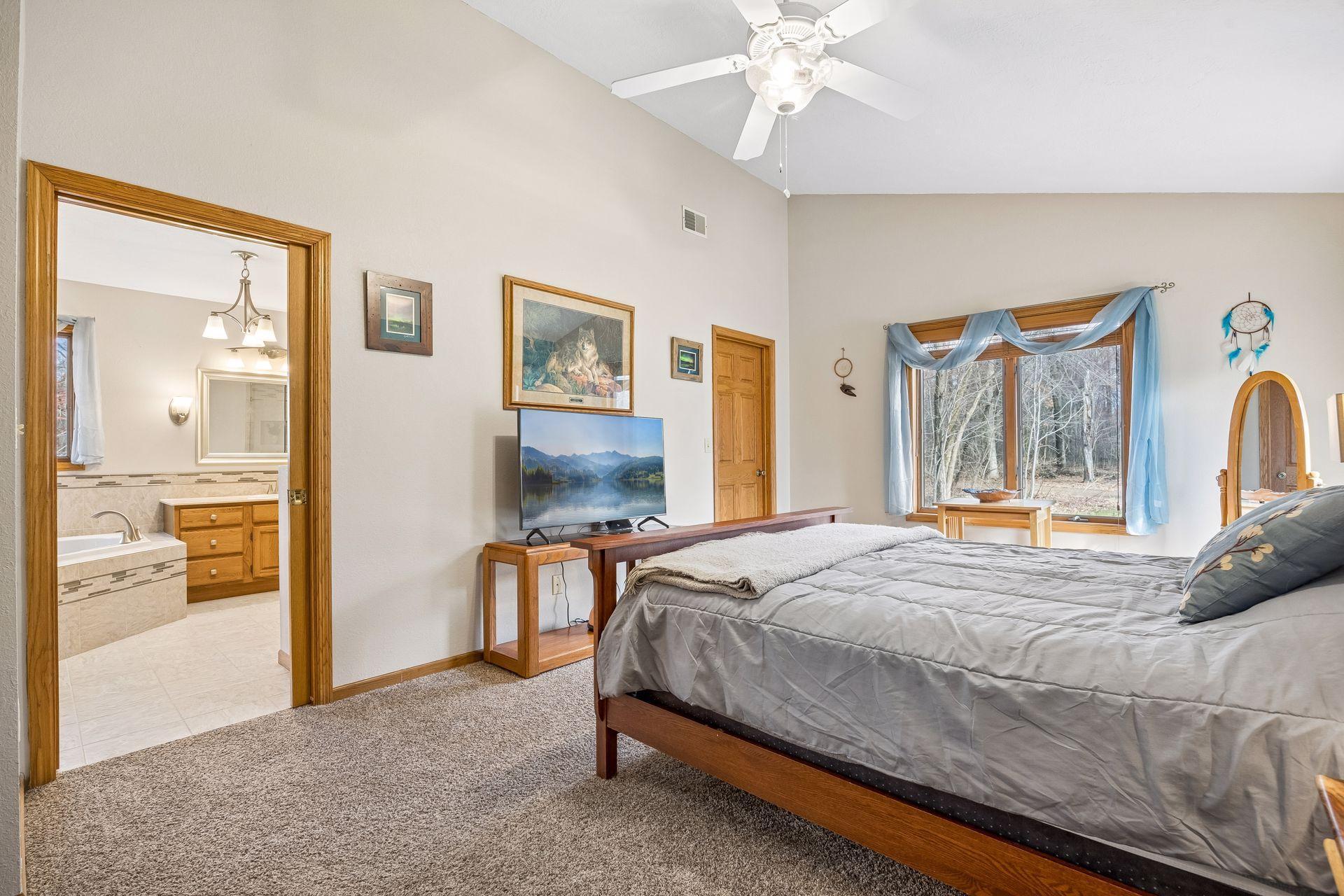 Primary suite featuring multiple windows, walk-in closet, and private bath.