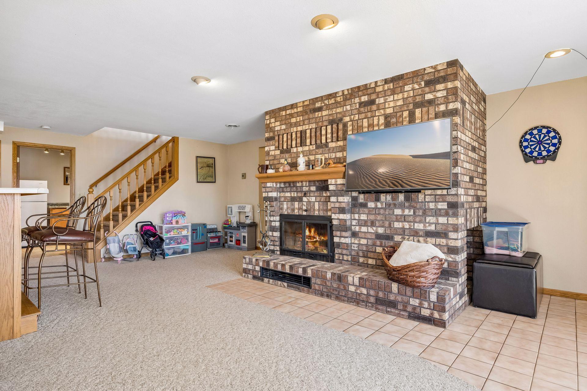 Cozy lower level living room with wood-burning fireplace and in-floor heat.