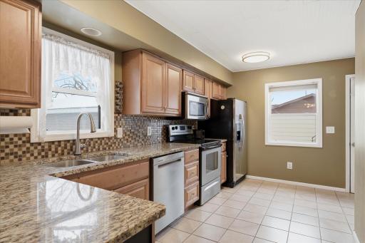 Kitchen features updated lighting, a tongue-and-groove ceiling, and a chalkboard accent panel on the end cabinet for added character and function.