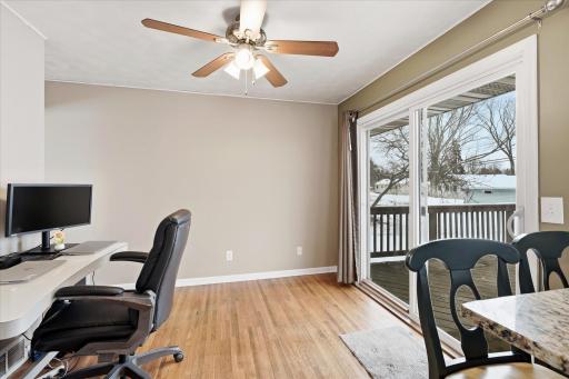 Dining room with hardwood floors, ceiling fan, and sliding glass door leading to the deck, offering great indoor-outdoor flow. The dining room is currently being used as a home office.